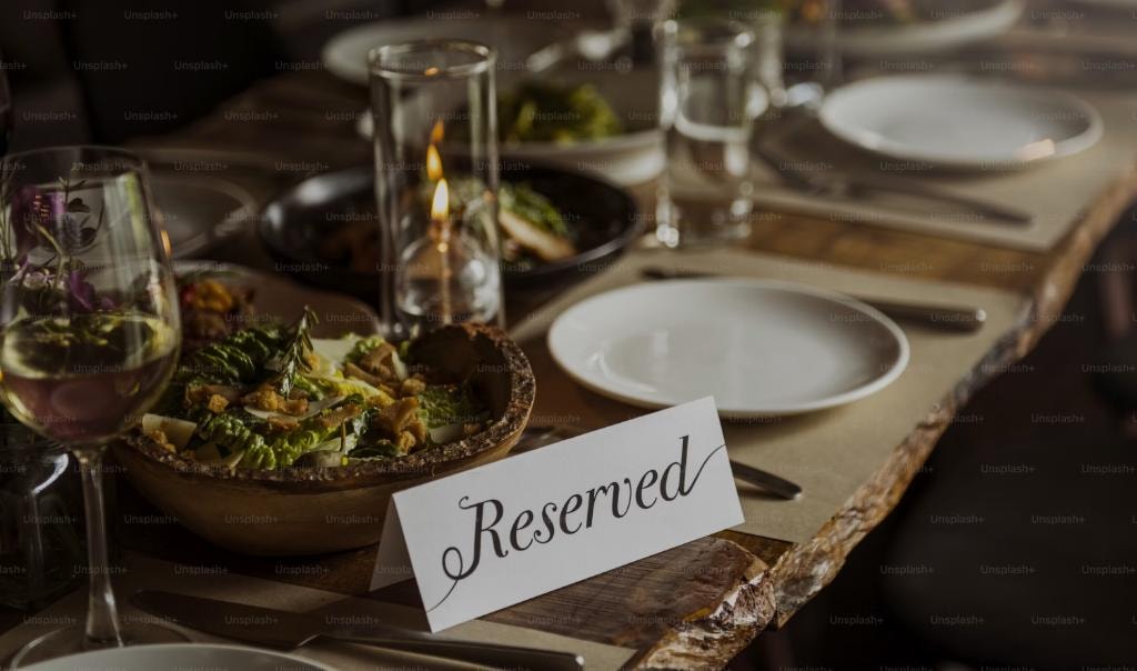 A reserved place card on an elegantly set dinner table — a seat is waiting with your name on it
