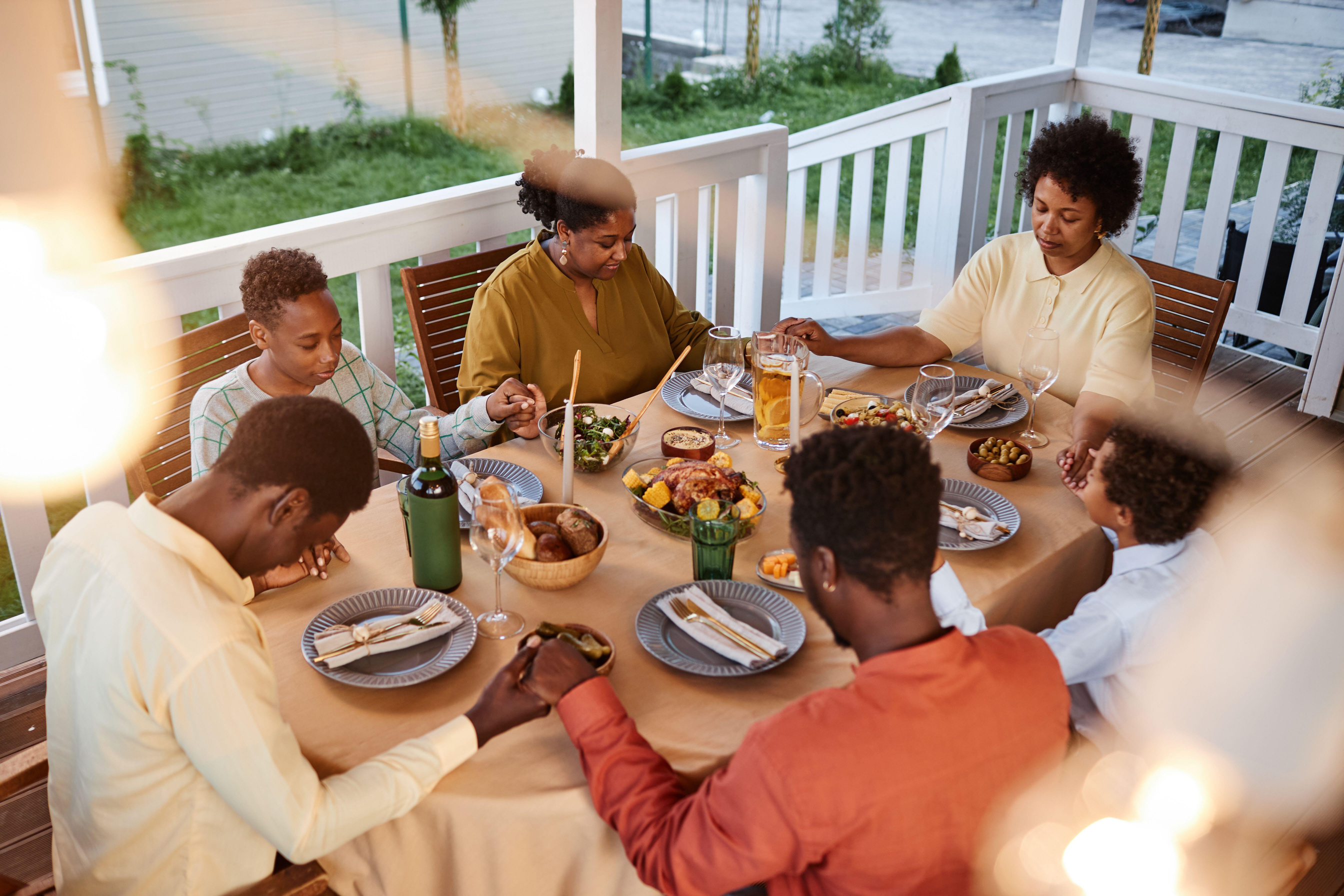 Family gathered around the table, praying before dinner